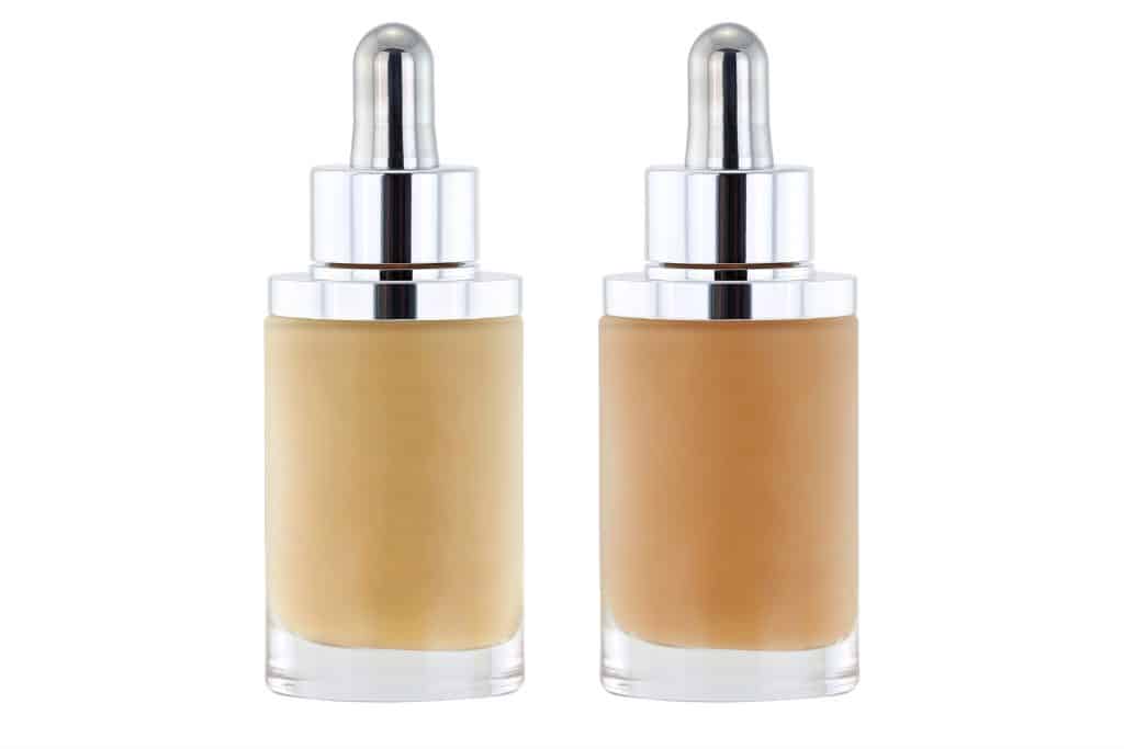 Glass Bottles of liquid foundation with dropper in pink and yellow undertone isolated on white