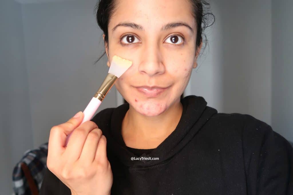Woman applying DIY aspirin face mask for acne